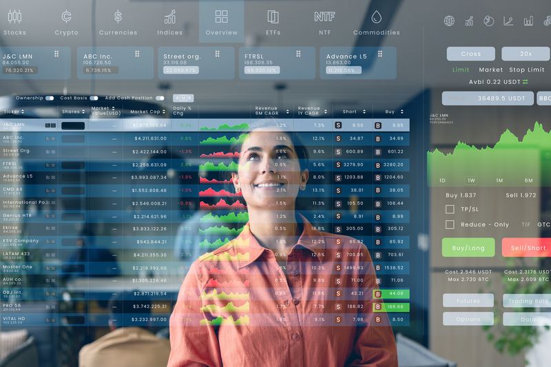 A woman smiling while looking at a transparent digital interface displaying financial data and charts