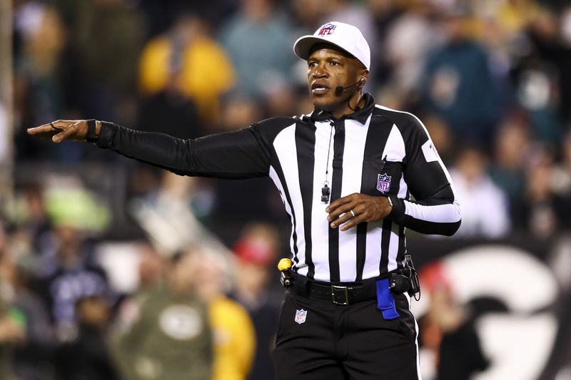 NFL referee Shawn Smith #14 signals for a penalty during an NFL football game between the Philadelphia Eagles and the Green Bay Packers at Lincoln Financial Field