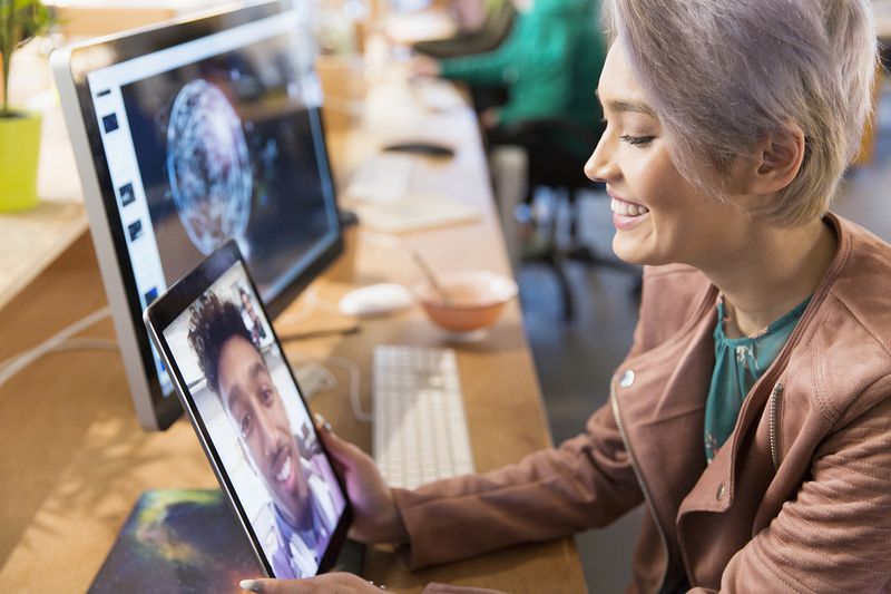 Creative Businesswoman Video Chatting With Colleague on Digital Tablet in Office
