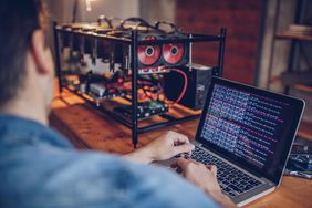 A person sitting in an office using a computer and mining cryptocurrency