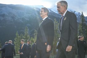 Group of men standing outdoors with mountains and trees in the background
