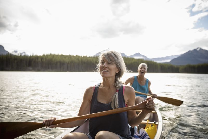 Mature couple canoeing on tranquil lake in Alberta, Canada