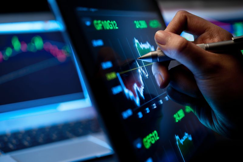 A person with a pen is pointing at a volatility chart.