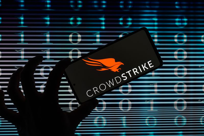 An illustration of a person holding a mobile device on which the Crowdstrike logo is shown. 
