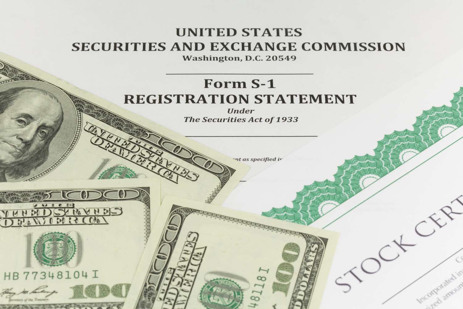 A closeup image of SEC Form S-1 Registration Statement, stock certificates, and hundred dollar bills.