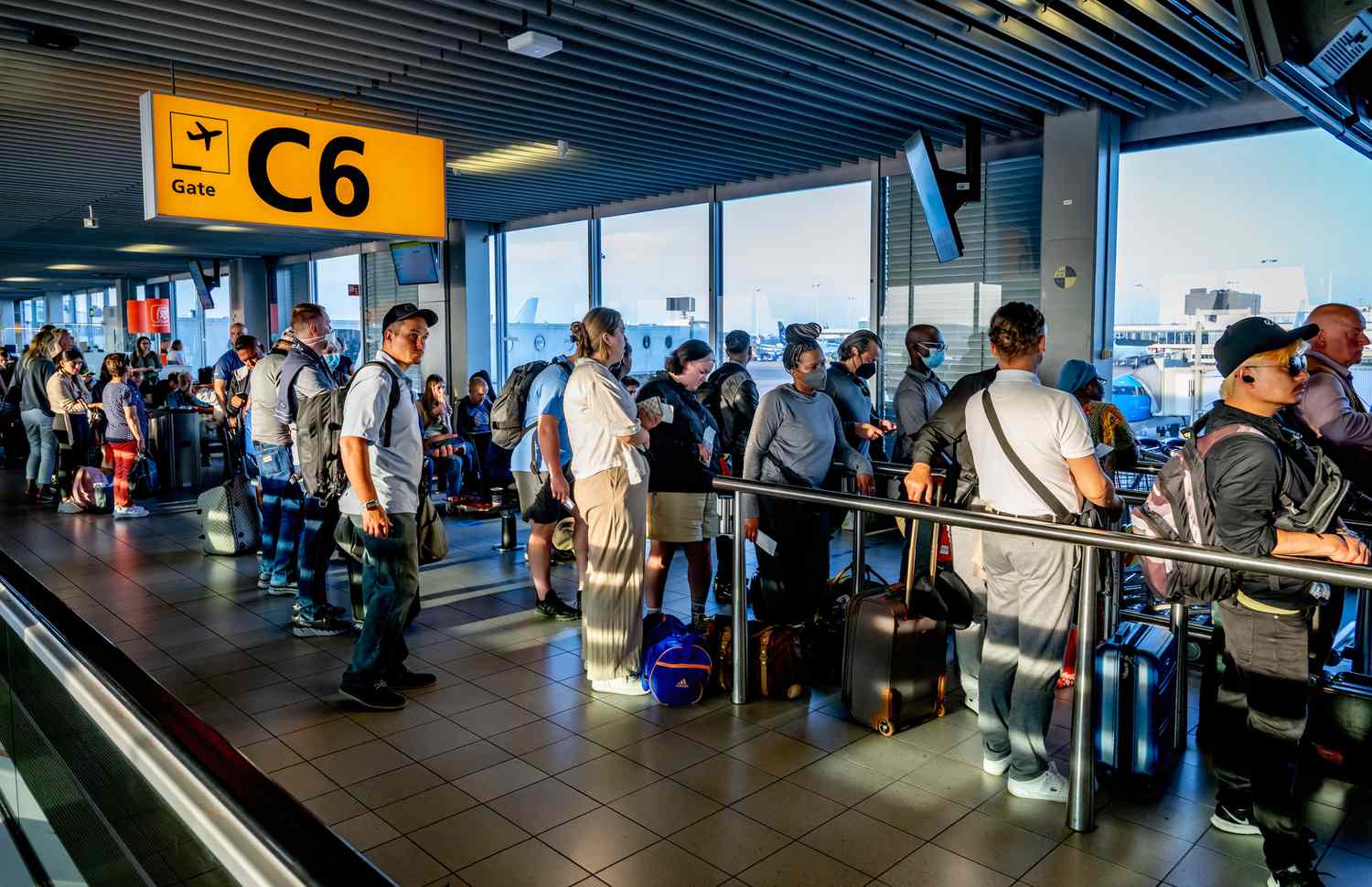 Travelers are seen waiting in departure halls to catch their flight from Schiphol airport in the Netherlands