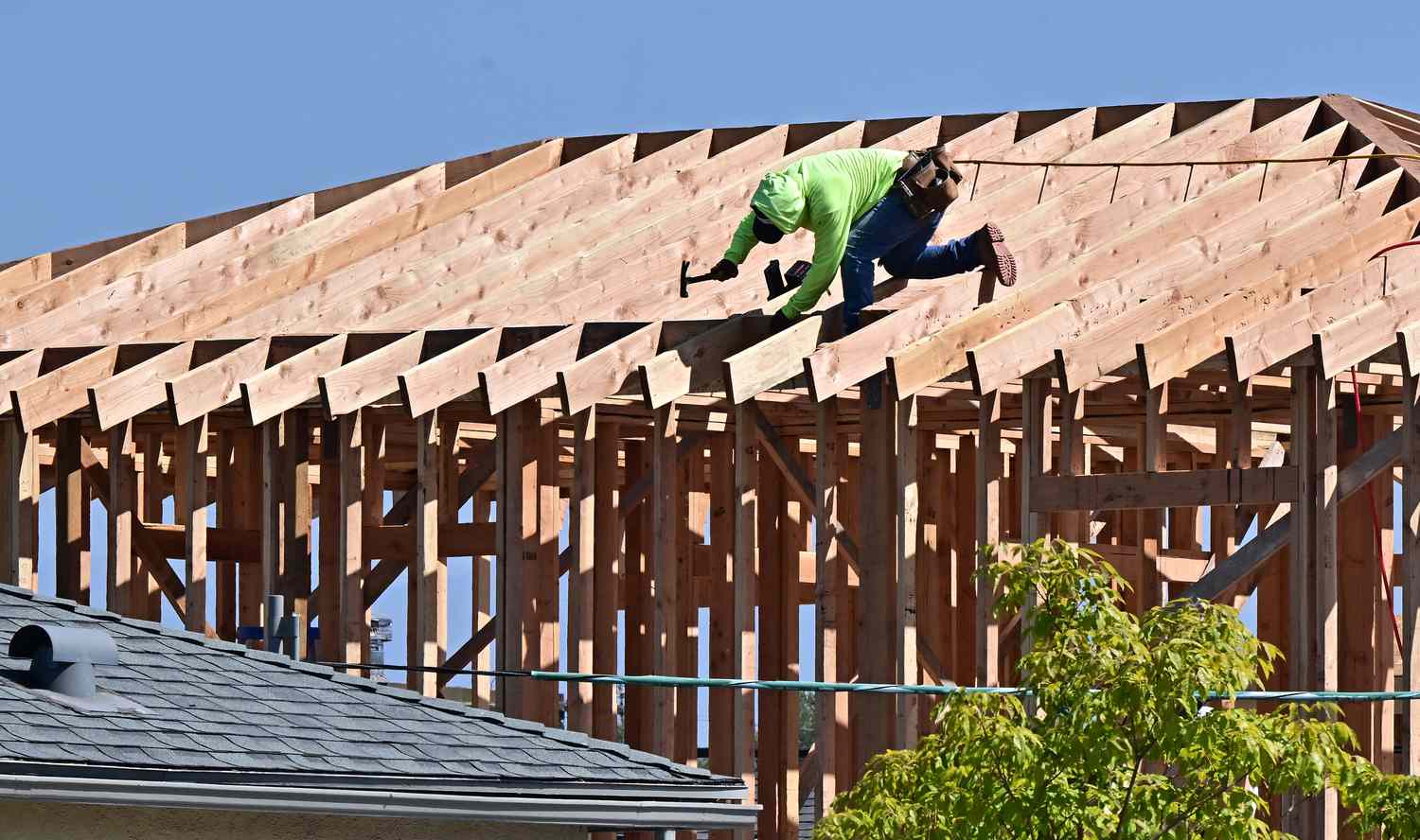 Construction workers work on the roof of a house being built in Alhambra, California on September 23, 2024.