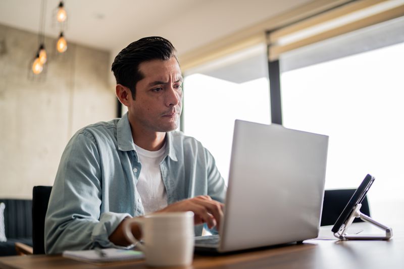Homeowner checking interest rate history and the news to decide whether to lock the current mortgage rate or not.