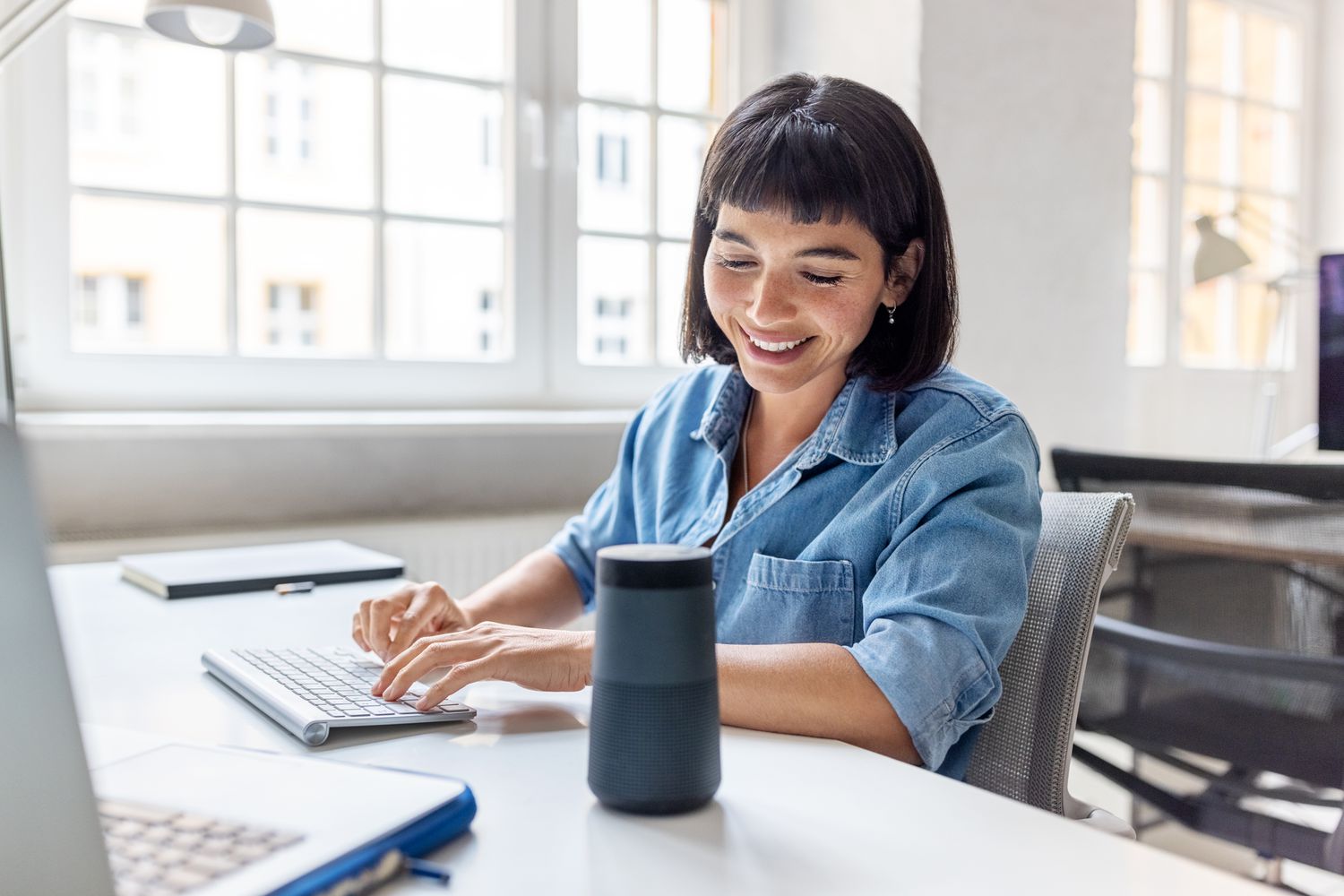Young woman talking to her smart speaker 