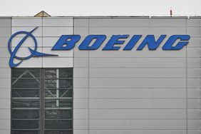 The blue Boeing logo is seen on the side of a gray building.
