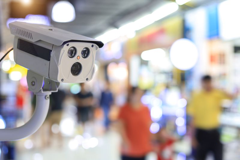 Surveillance Camera in a Retail Store with Blurred-Out People Shopping in Background