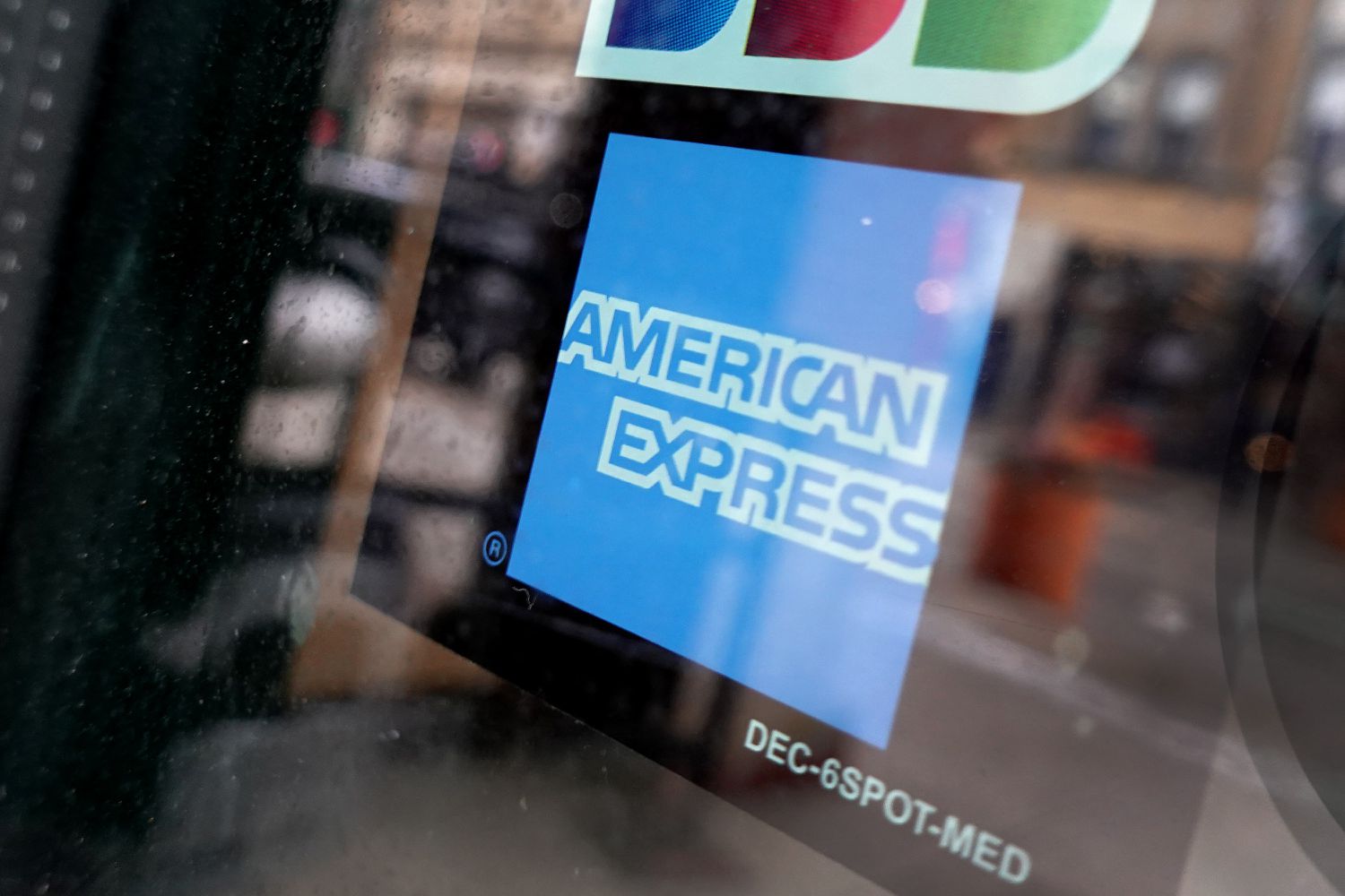 A sticker pasted at the entrance of a business lets customers know that they accept American Express credit cards
