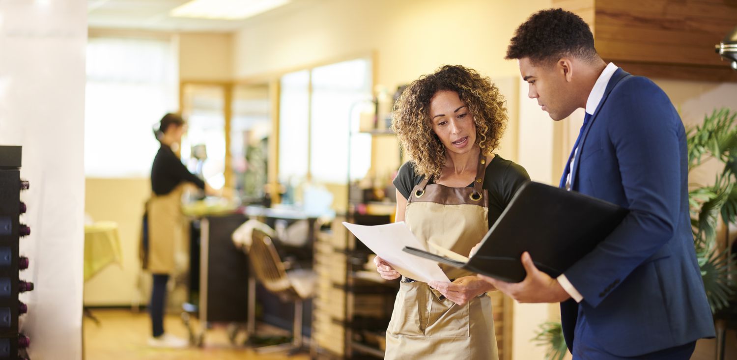 Hair salon owner chatting to bank representative