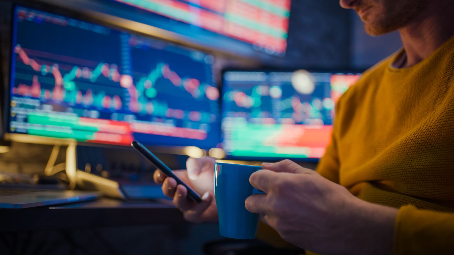 Worker with coffee and smartphone with screen in background