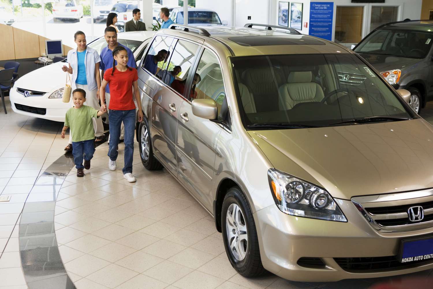 Family looking at new cars in a showroom