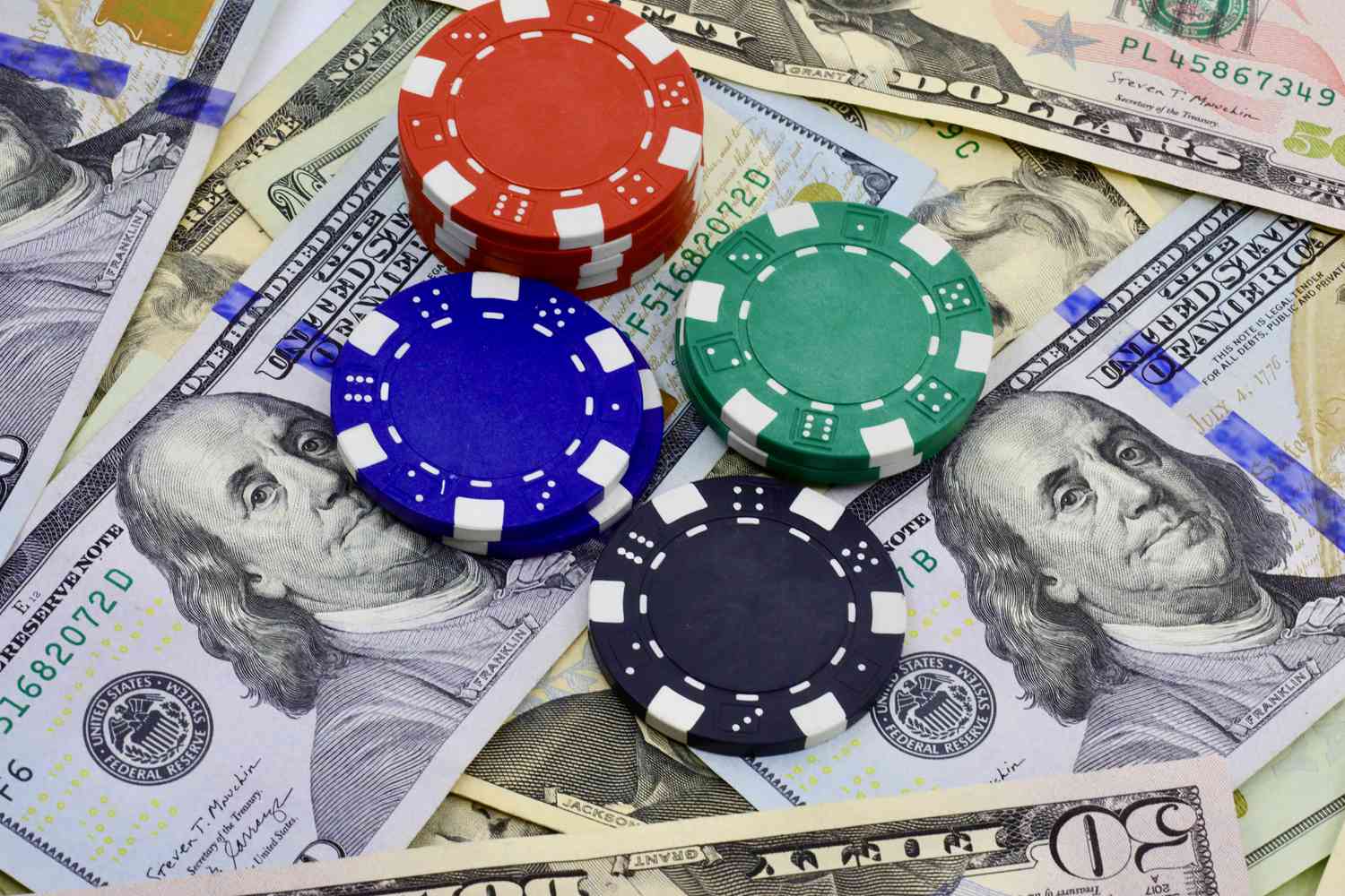 A stock image of poker chips sitting on top of US dollars. 