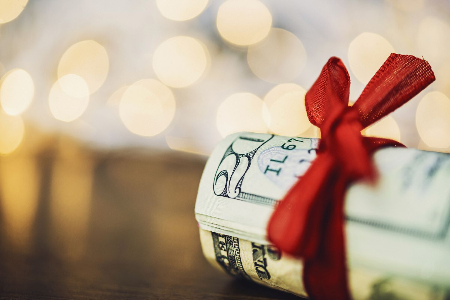 Christmas cash. Wad of American currency tied with red ribbon