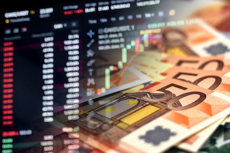 A closeup of 50 Euro notes superimposed over a screen showing stock data.