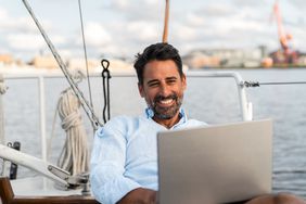 Person with a laptop in a sailboat.