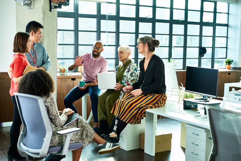 A diverse group of office workers casually sitting in a circle