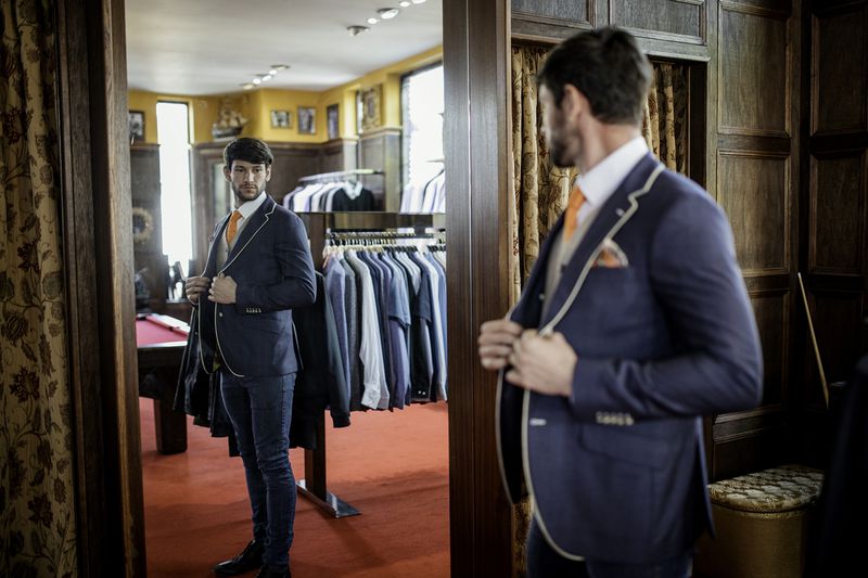 Man Admiring Himself in a Mirror in a Menswear Shop