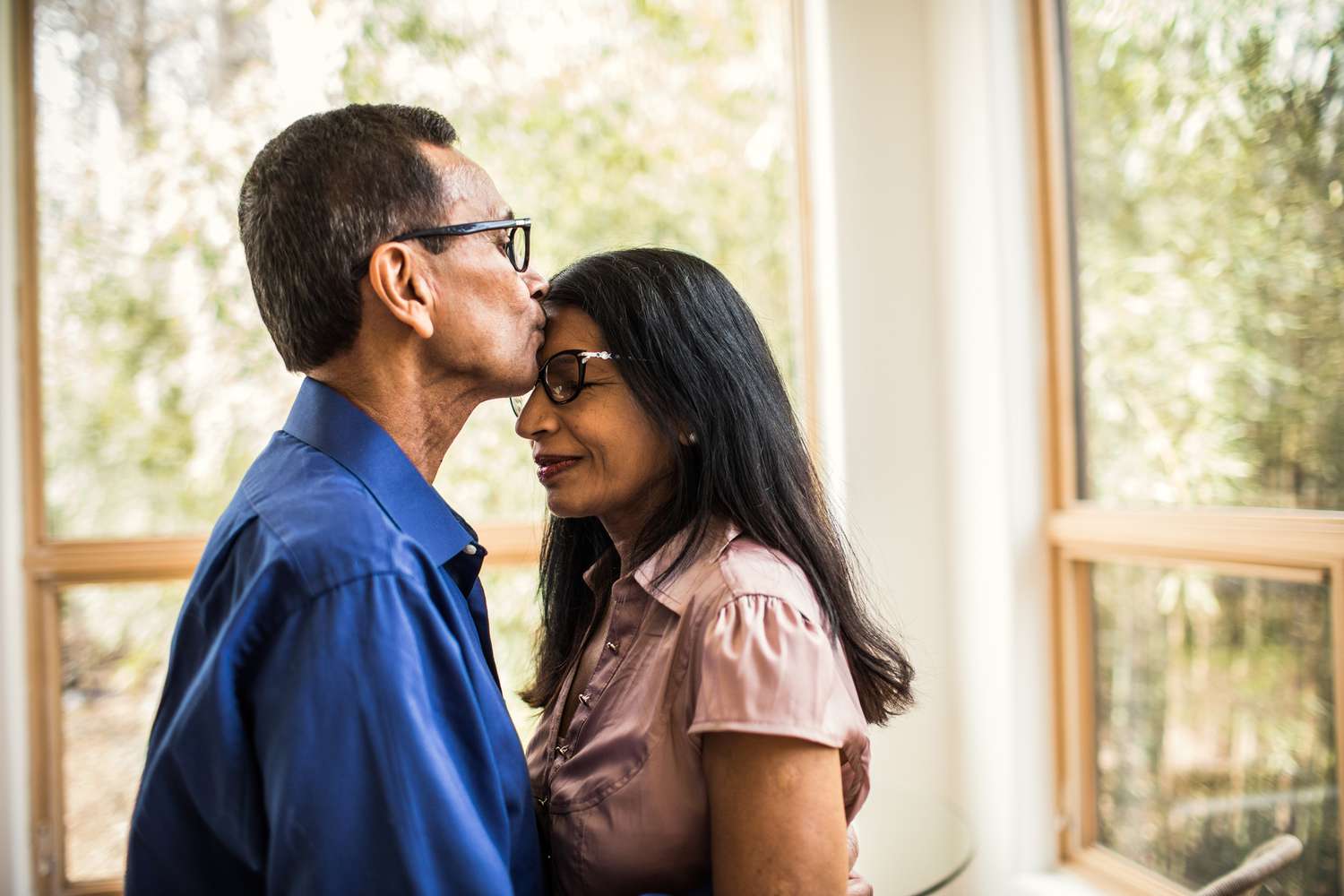 Senior man kissing wife at home