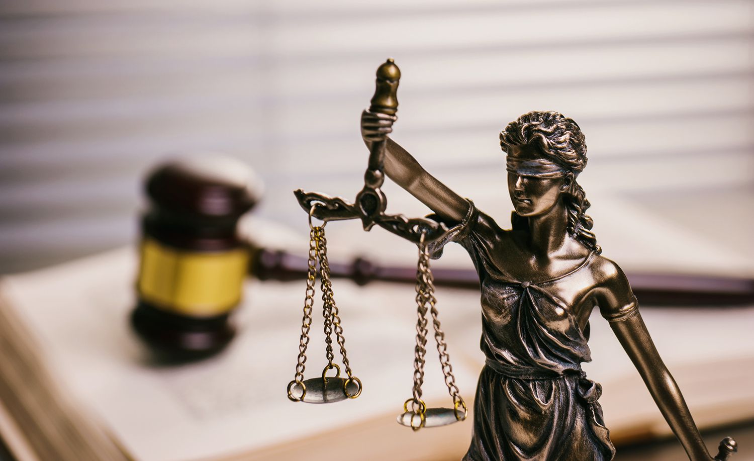 Close Up Of Lady Justice Against Gavel On Book