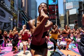 People practicing yoga in Times Square, New York, demonstrate the concept of cultural diffusion.