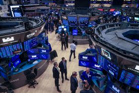 Traders are surrounded by computer screens on the floor of the New York Stock Exchange.