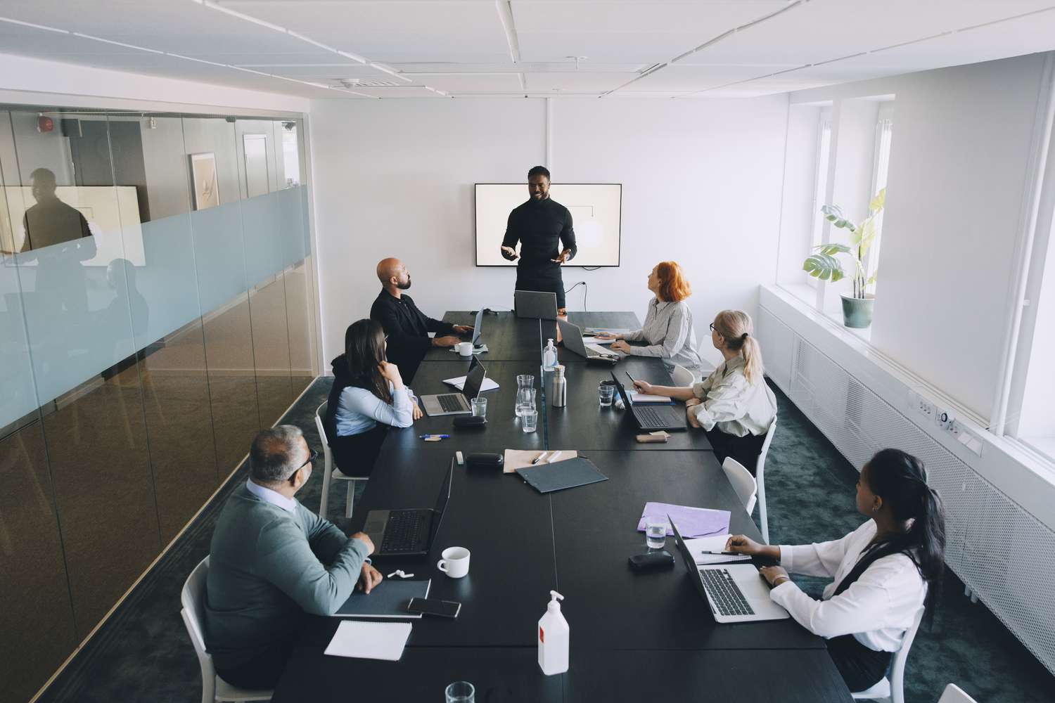High angle view of business worker giving presentation colleagues in board room at office