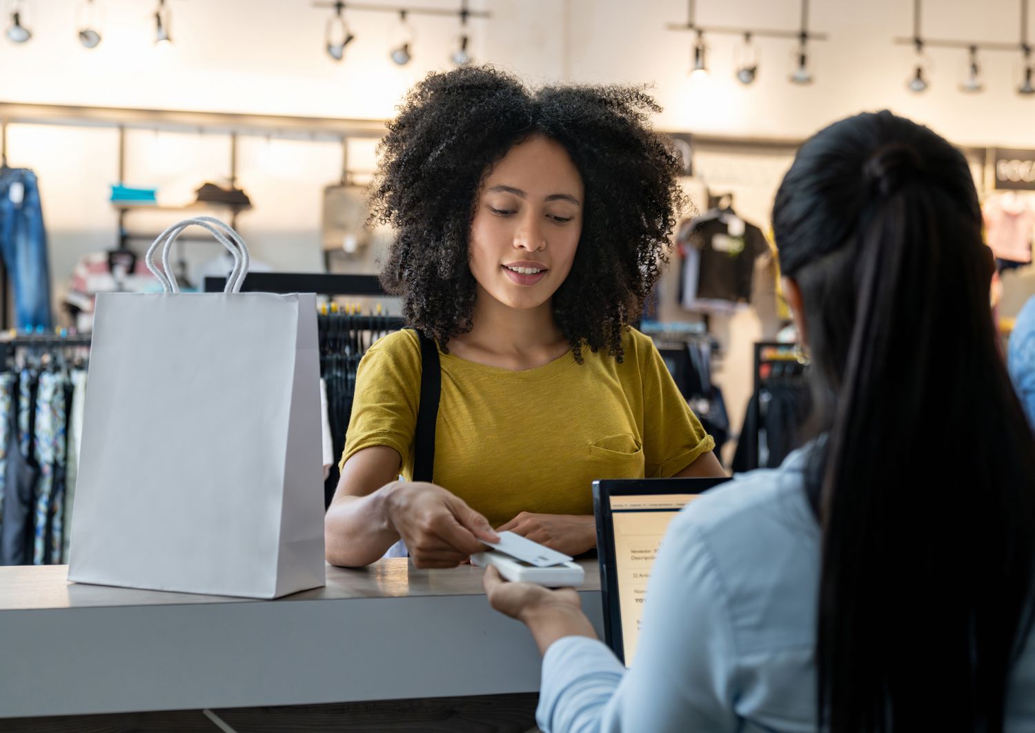 A customer paying for clothes shopping at the store using Sears credit card for rewards.