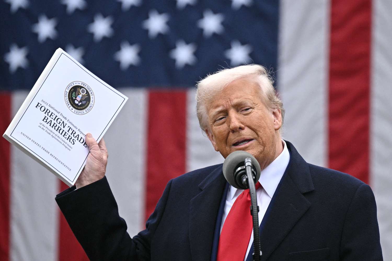 U.S. President Donald Trump holds up his tariff policy with a U.S. flag in the background at the White House in Washington, DC, on April 2, 2025.