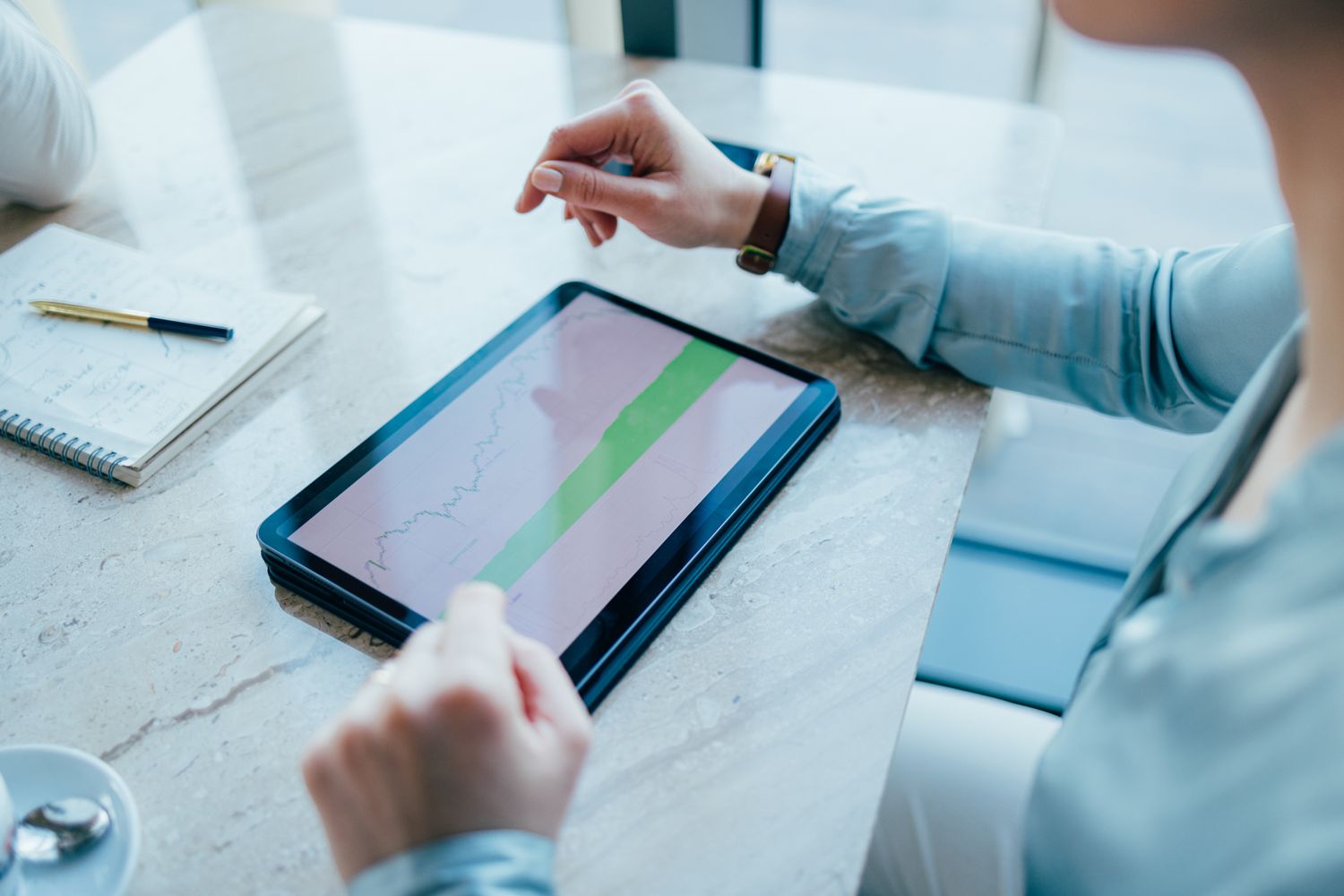Person looking at ZEW Indicator of Economic Sentiment on tablet to gauge market trends in upcoming months.