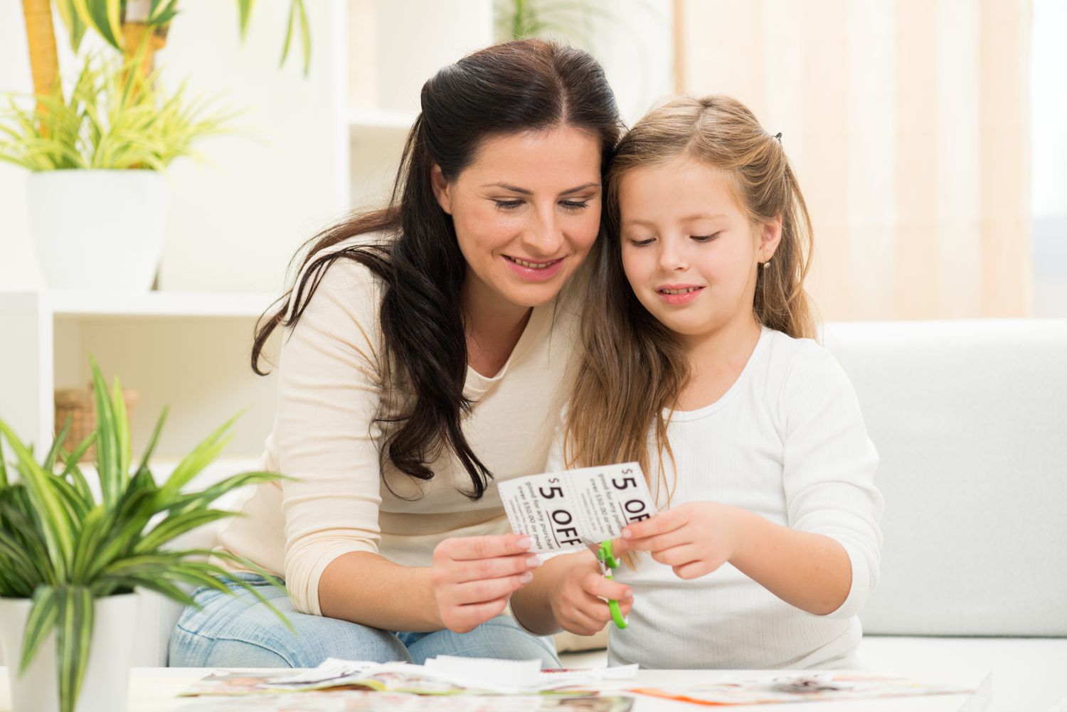 Mother and daughter cutting coupons
