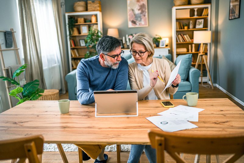 Mature couple paying bills together and managing home budget