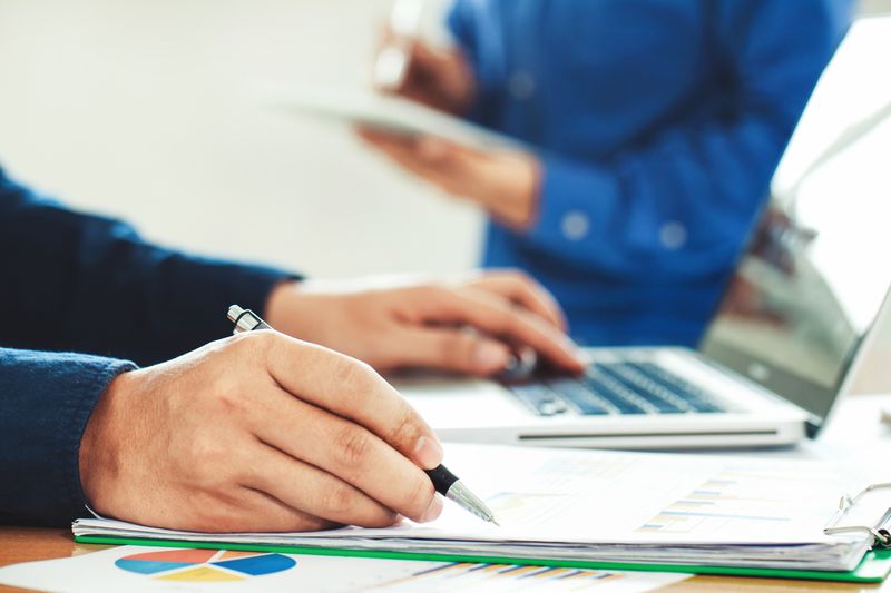 Credit rating agent assigns ratings to individuals on laptop based on instruction documents.