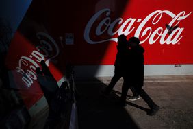 People walk past a Coca-Cola logo in Seoul earlier this month. 