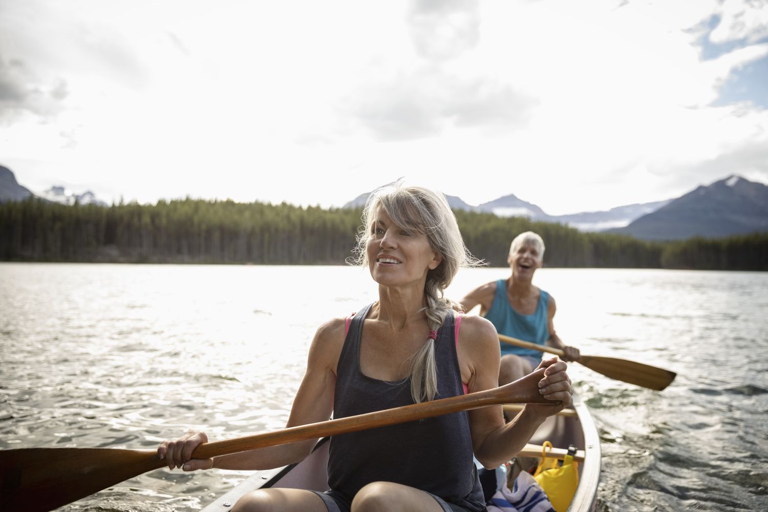 Mature couple canoeing on tranquil lake, Alberta, Canada