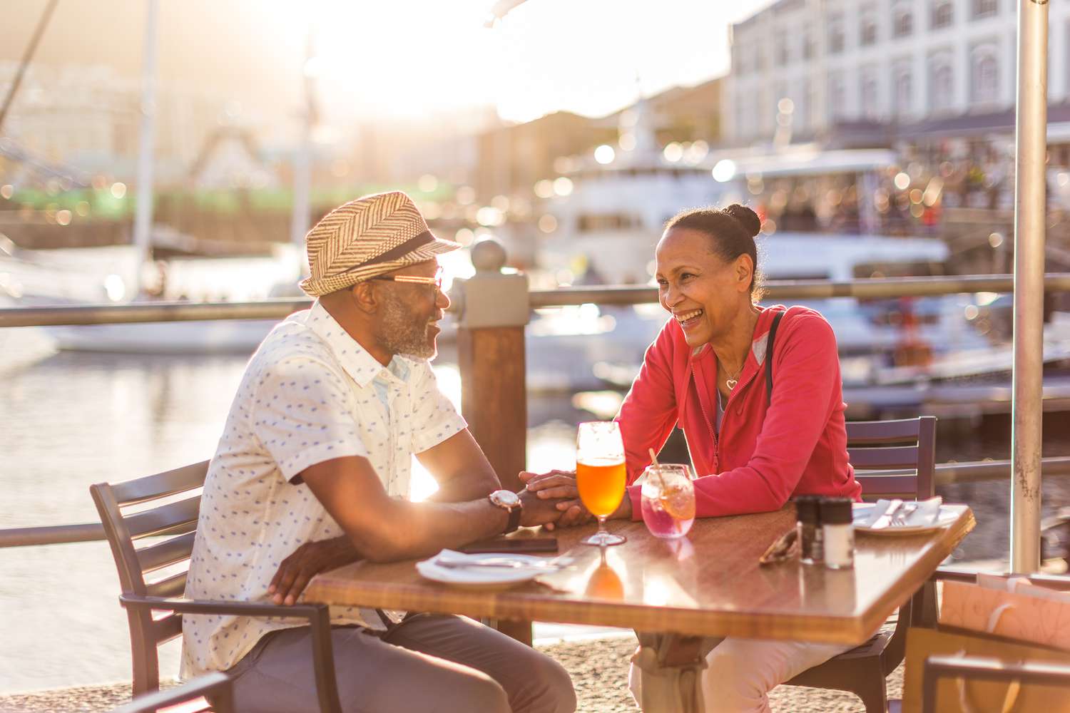 An older couple has a drink at an outdoor cafe.