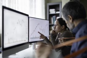Couple checking on trading positions and stock markets on TradingView desktop app.