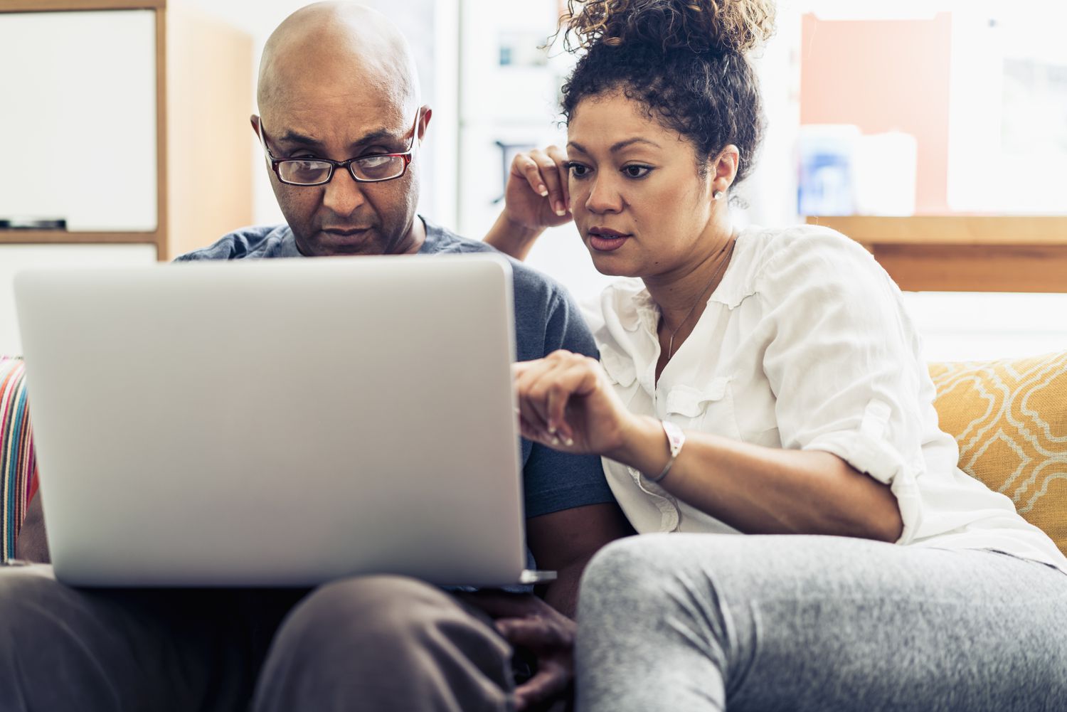 Black mid-age couple studying laptop together