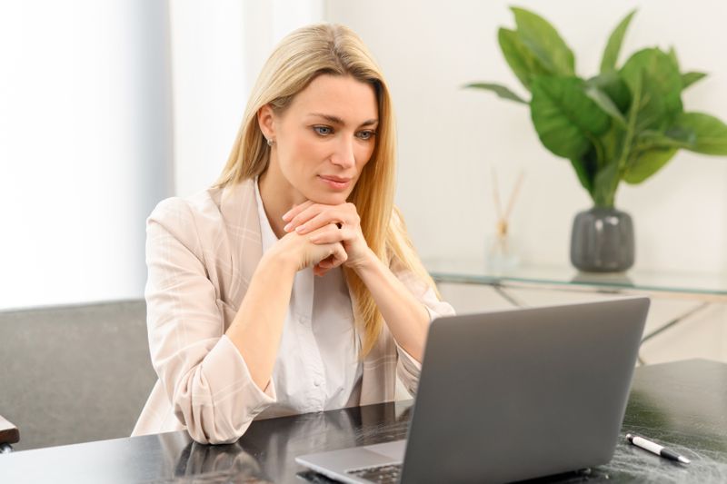 Woman in her 30s looking at bank rates on her laptop