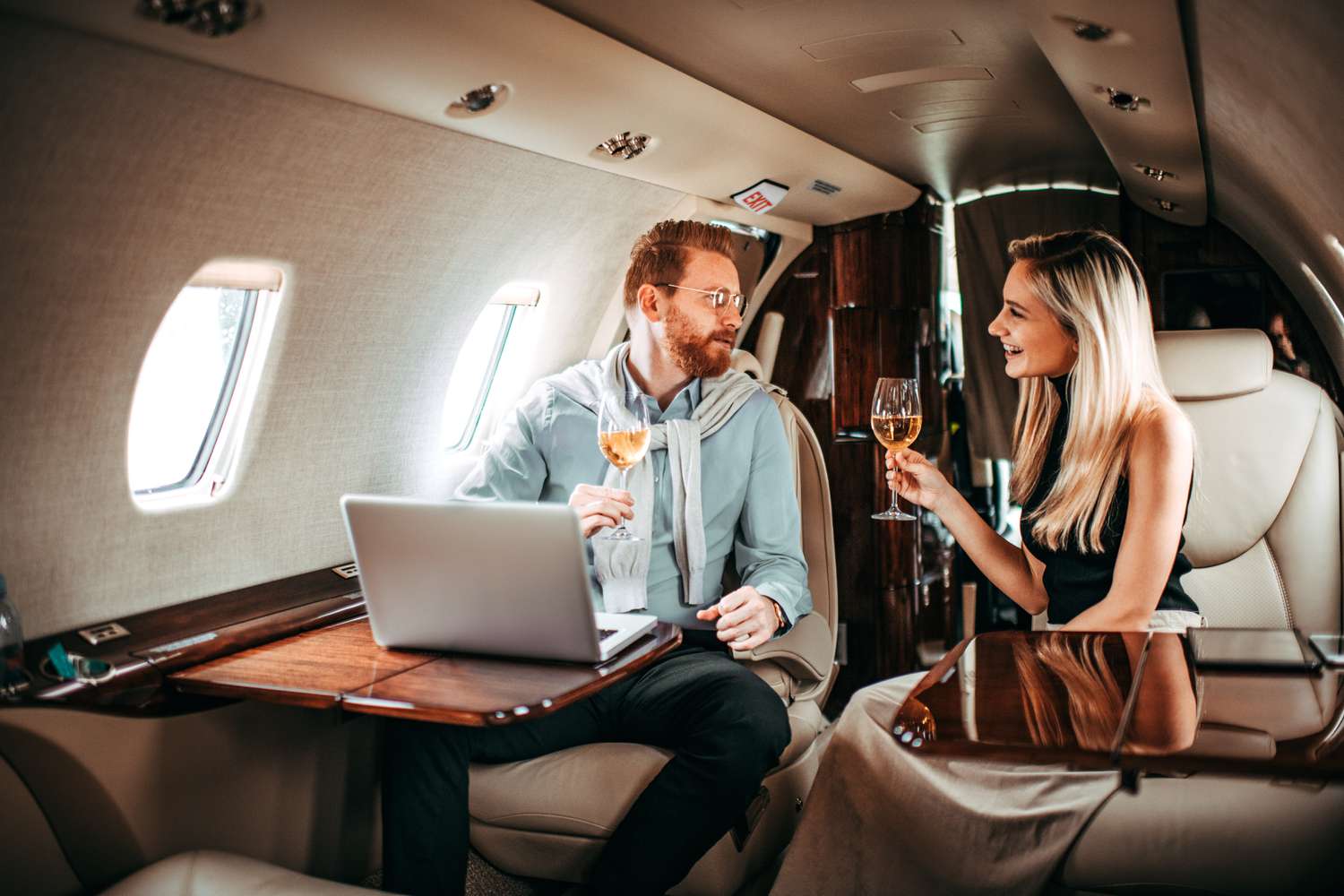A wealthy couple toast each other as they fly on a private jet in a display of conspicuous consumption.