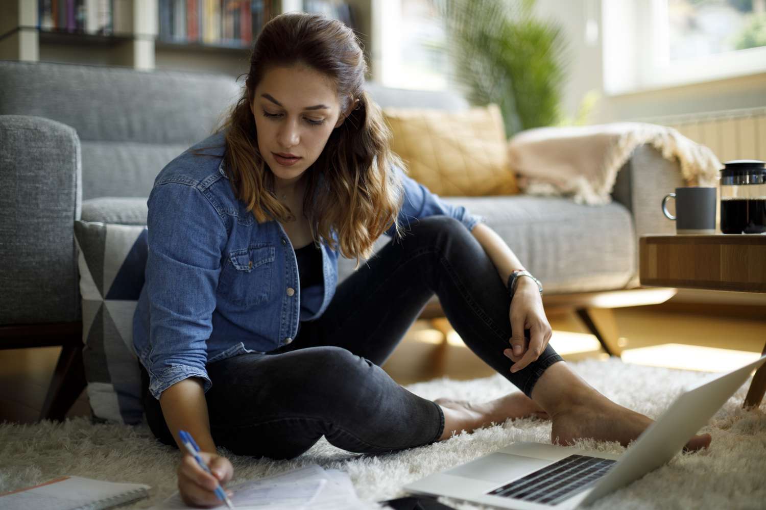 Woman calculating finances at home. 
