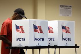 A person voting in a booth for the 2025 General Election in Detroit
