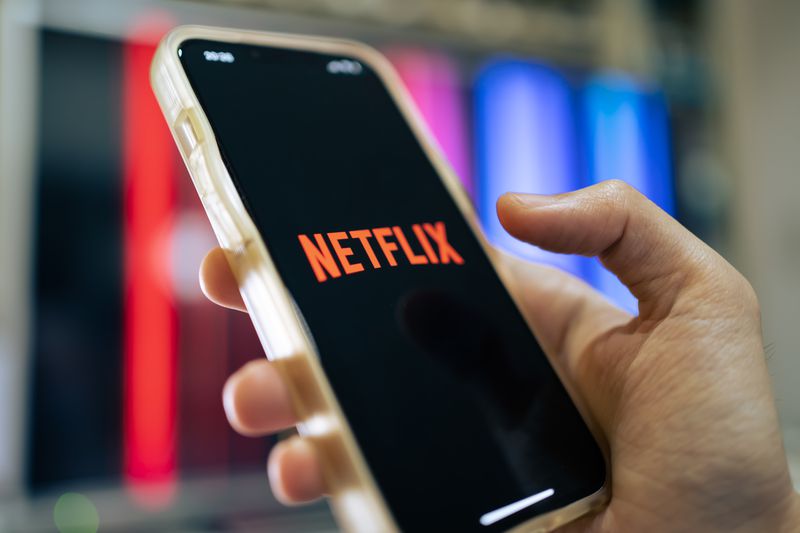 Person holding a mobile devise with Netflix on the screen