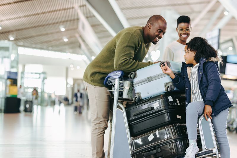 A family with a pile of luggage has a discussion.