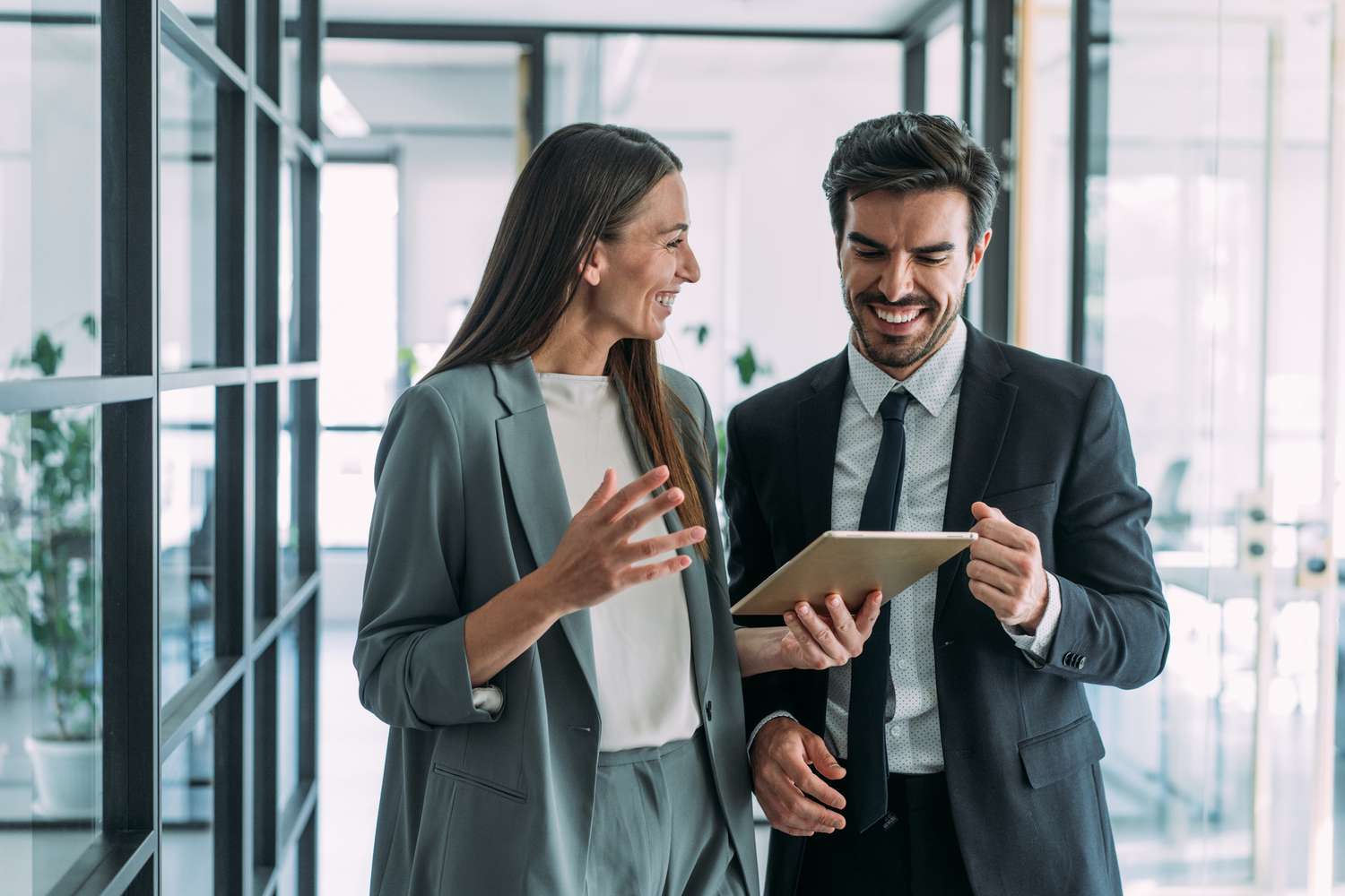 A couple is a having a discussion with a device in an office setting.