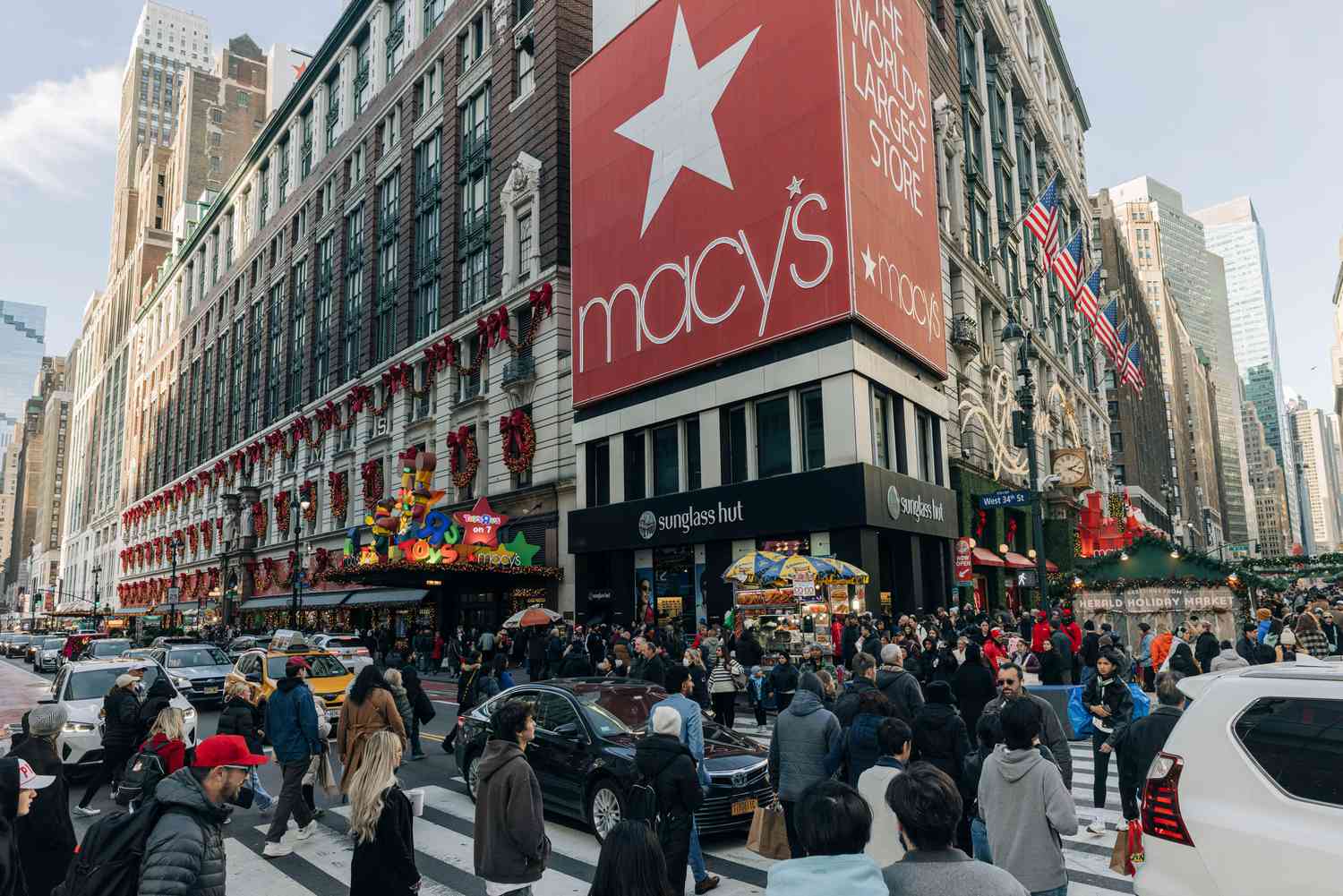 People and cars are seen on the street outside the flagship Macy's store in New York City.