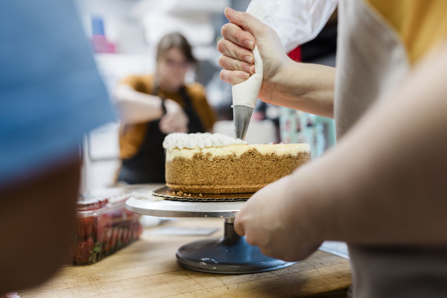Small-business owner frosting a cake.